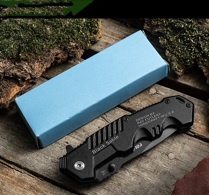 7Cr17 Stainless Steel Folding Knife with Black Handle and Blue Packaging Box on Wooden Surface