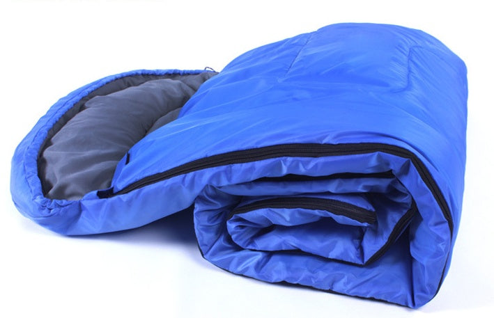 Blue portable sleeping bag with waterproof polyester fabric, shown rolled up with a cap and Velcro side closure.