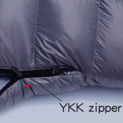 Goose down sleeping bag with YKK zipper detail and compression sack for winter camping.