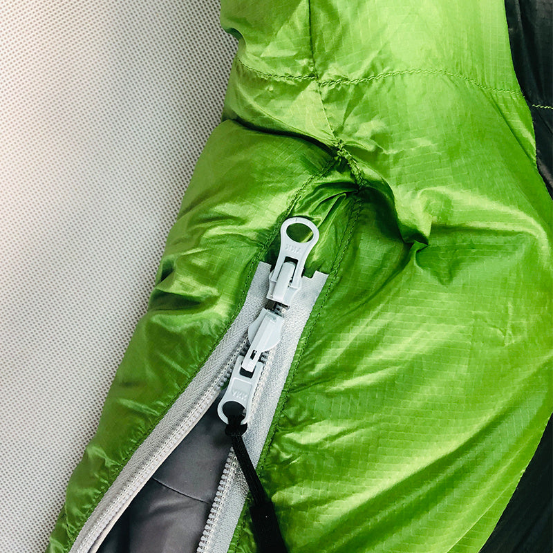 Green Kamperbox down sleeping bag with close-up of durable zipper and 380T Nylon shell for cold weather camping.