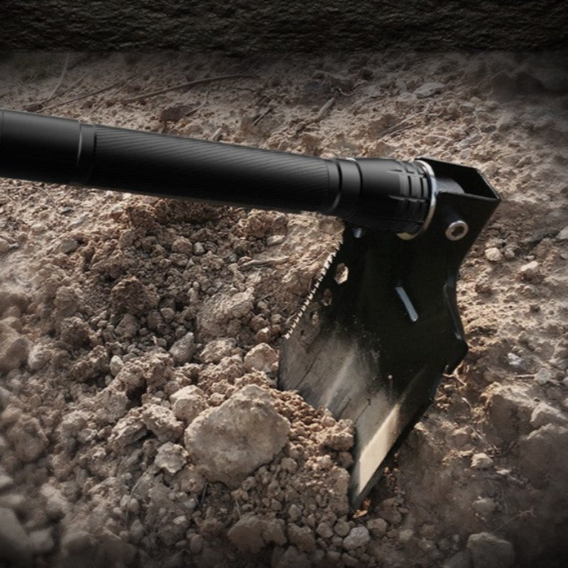 black Folded Military Shovel while digging ground