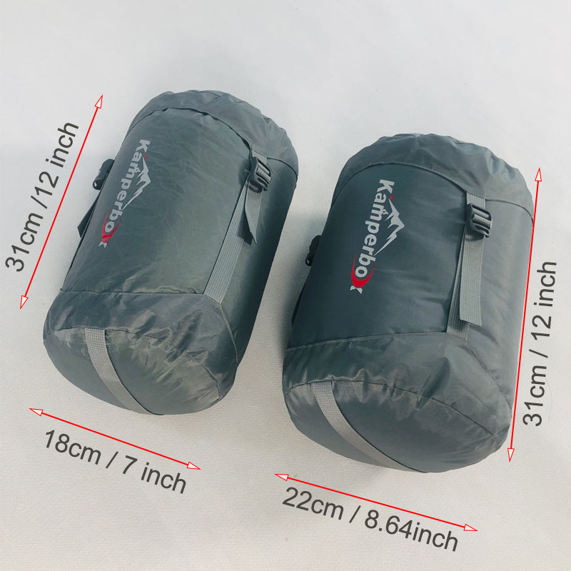 Two Kamperbox duck down sleeping bags in compression sacks with dimensions marked, ideal for cold weather camping.