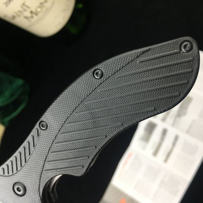 Close-up of the textured handle of the 8CR13 MOV Survival Folding Knife with all-steel and ABS engineering.