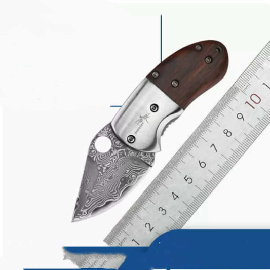 Mini Damascus Steel Folding Knife with Red Sandalwood Handle next to a ruler showing its dimensions.